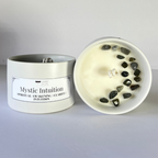 Candle with labradorite stones inside labeled 'Mystic Intuition' on a gray background