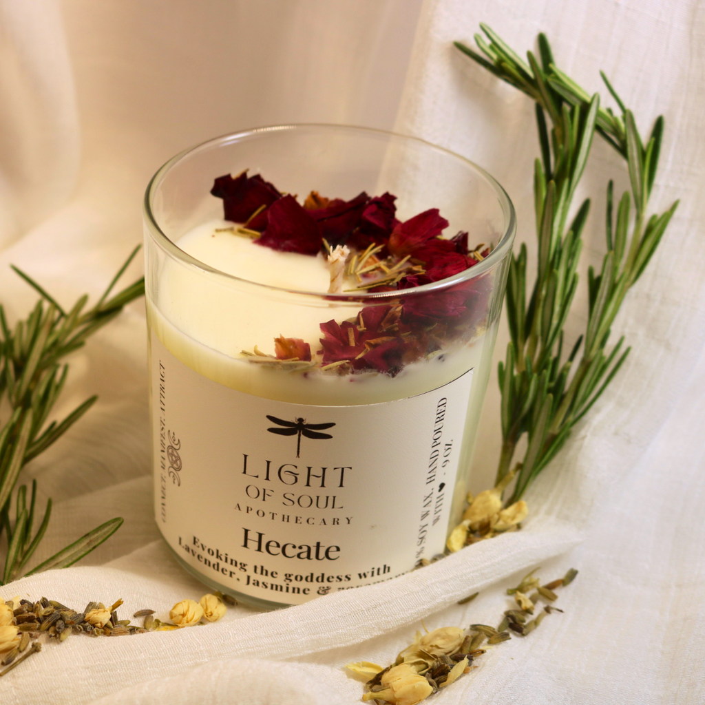Candle labeled 'Hecate' from 'Light of Soul Apothecary' with dried flowers and herbs  rosemary_roses 